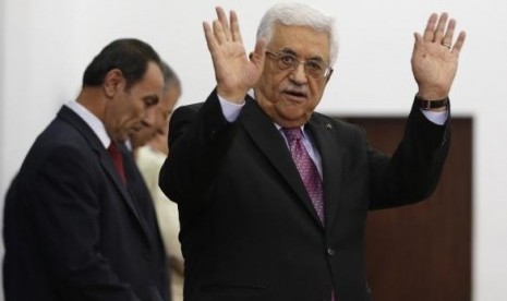 Palestinian President Mahmoud Abbas waves during a swearing-in ceremony of the unity government, in the West Bank city of Ramallah June 2, 2014.