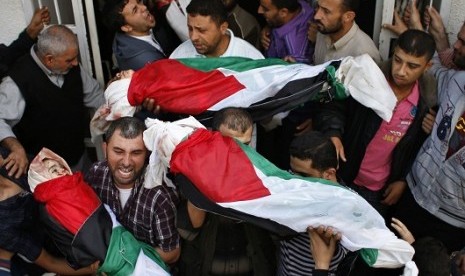 Palestinians carry the bodies of four siblings, who are children of the al-Dalo family, out of a hospital morgue during their funeral in Gaza City November 19, 2012. 