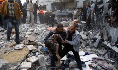  Palestinians carry the dead body of a child from under the rubble of a house after an Israeli air strike in Gaza City November 18, 2012. 