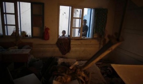 Palestinians look at a damaged classroom in a United Nation-run school sheltering Palestinians displaced by an Israeli ground offensive, that witnesses said was hit by Israeli shelling, in Jebalya refugee camp in the northern Gaza Strip July 30, 2014.