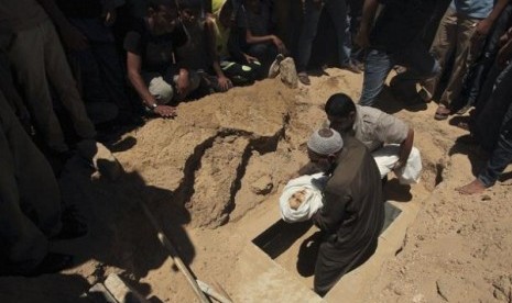 Palestinians prepare to bury the body of five-year-old boy Abdulrahman Khatab, who hospital officials said was killed in an Israeli air strike, on July 11, 2014.