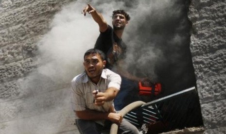 Palestinians react as they put out a fire in an apartment which witnesses said was hit by an Israeli air strike in Beit Lahiya in the northern Gaza Strip August 10, 2014.