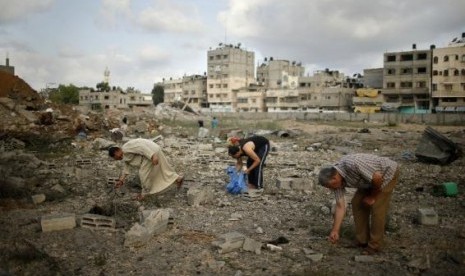 Palestinians search for scattered body parts amongst the rubble of Tayseer Al-Batsh's family house, which police said was destroyed in an Israeli air strike in Gaza City July 13, 2014.