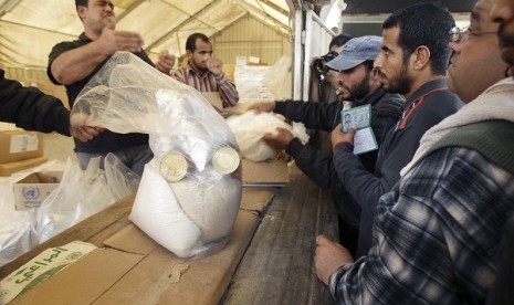 Palestinians wait to receive food supplies from the United Nations Relief and Works Agency (UNRWA) headquarters in Rafah in the southern Gaza Strip November 20, 2012.   