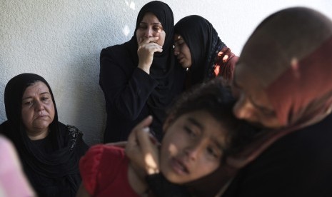 Palestinians weep after what medics said was an Israeli shell that hit a U.N-run school sheltering Palestinian refugees, at a hospital in Jabaliya in the northern Gaza Strip July 24, 2014. At least 15 people were killed and many wounded on Thursday when Is