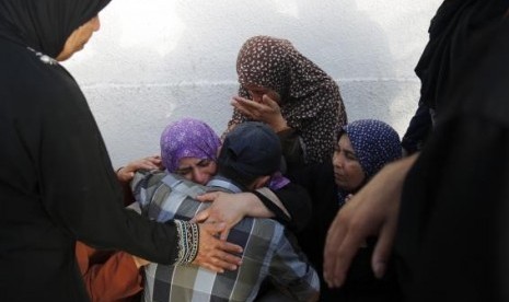 Palestinians, whose relatives were killed by what medics said was Israeli shelling near a market in Shejaia, mourn outside a morgue in Gaza City July 30, 2014.