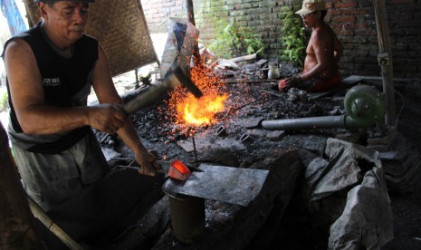 Pande besi membuat cangkul secara tradisional di sentra kerajinan cangkul, Tulungagung, Jawa Timur, Rabu (2/11).