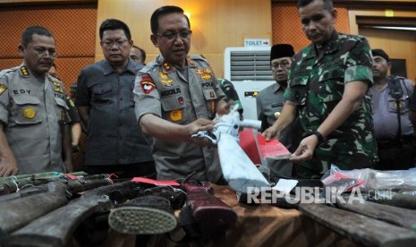 Pangdam II Sriwijaya Mayjen TNI Irwan (kedua kanan), Gubernur Jambi Fachrori Umar (ketiga kanan), Kapolda Irjen Pol Muchlis (tengah), dan petugas terkait memeriksa barang bukti saat rilis kasus tindak pidana penghadangan, perusakan, dan penganiayaan di Mapolda Jambi, Jumat (19/7/2019).