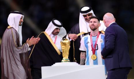  Pangeran Jassim bin Hamad bin Khalifa Al Thani (kiri) bertepuk tangan saat Emir Qatar Sheikh Tamim bin Hamad Al Thani memberi jubah tradisional Arab Bisht pada Lionel Messi dari Argentina di sebelah presiden FIFA Gianni Infantino (kanan) selama upacara penghargaan untuk Piala Dunia FIFA 2022 Final antara Argentina dan Prancis di stadion Lusail, Lusail, Qatar, Ahad, 18 Desember 2022. 