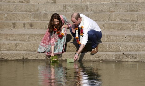 Pangeran William dan Kate Middleton saat meletakkan bunga untuk mengambang di Banganga Water Tank di Mumbai, Ahad (10/4).