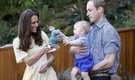 Pangeran William menggendong Pangeran George ketika istrinya, Catherine, memberikan boneka mainan dalam kunjungan mereka ke kebun binatang Taronga, Sydney, Ahad (20/4).