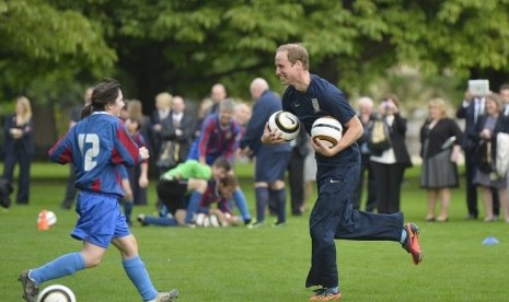 Pangeran William terlihat memakai sepatu Nike pemberian Wayne Rooney dalam laga eksibisi di Istana Buckingham