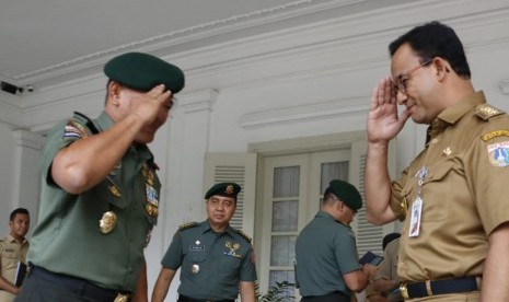 Gubernur DKI Jakarta Anies Rasyid Baswedan (kanan) memberi hormat kepada Pangkostrad Letjen Besar Harto Karyawan di Balai Kota DKI.