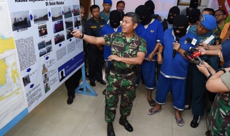 Panglima Komando Armada RI Kawasan Barat (Pangarmabar) Laksamana Muda TNI A. Taufiq R (tengah) menjelaskan kasus perompakan saat rilis tiga perompak kapal berbendera Singapura MT Joachim di Makoarmabar, Jakarta, Rabu (23/12).  (Antara/Hafidz Mubarak A.)