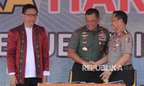 Panglima TNI Jenderal Gatot Nurmantyo (tengah), Kapolri Jenderal Tito Karnavian (kanan), dan Ketua Dewan Pers Yoseph Adi Prasetyo melakukan penandatanganan nota kesepahaman penanganan berita hoax saat saat acara puncak perayaan Hari Pers Nasional (HPN) 201