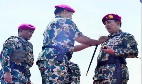 Panglima TNI Laksamana TNI Yudo Margono (tengah) memakaikan brevet kepada Kapolri Jenderal Pol Listyo Sigit Prabowo (kanan) saat upacara pengangkatan warga kehormatan Korps Marinir TNI AL di Pulau Damar, Kepulauan Seribu, Jakarta, Selasa (24/1/2023).