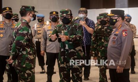 Panglima TNI Marsekal TNI Hadi Tjahjanto (kedua kanan) berbincang dengan Kapolri Jenderal Pol Listyo Sigit Prabowo (kanan) saat meninjau pelaksanaan serbuan vaksinasi COVID-19 di JIExpo Kemayoran, Jakarta, Ahad (4/7/2021). Panglima TNI menargetkan 8,7 juta warga di DKI Jakarta tervaksinasi. 