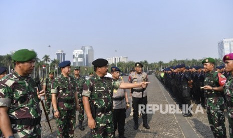 Panglima TNI Marsekal TNI Hadi Tjahjanto (ketiga kanan) dan Kapolri Jenderal Pol Tito Karnavian (kedua kanan) didampingi KASAD Jenderal TNI Andika Perkasa (keempat kanan), Wakil KASAU Marsdya TNI Fahru Zaini Isnanto (kedua kanan) dan Pangdam Jaya Mayjen TNI Eko Margiyono (kiri) meninjau personel gabungan saat Apel Gelar Pasukan Pengamanan Pelantikan Presiden Dan Wakil Presiden periode 2019-2024 di Lapangan Silang Monas, Jakarta, Kamis (17/10/2019). 