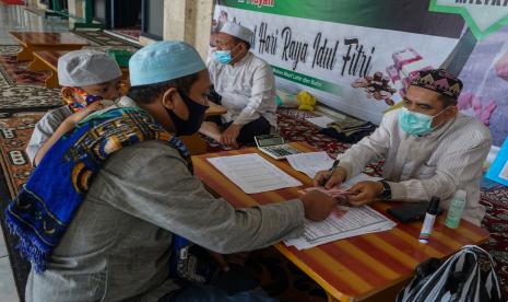 Panitia Lembaga Amil Zakat (LAZ) menerima zakat fitrah dari warga di Masjid Raya Nurul Islam, Palangkaraya, Kalimantan Tengah, Selasa (11/5/2021). Ilustrasi. Hukum Mengirim Zakat Fitrah ke Negara Lain