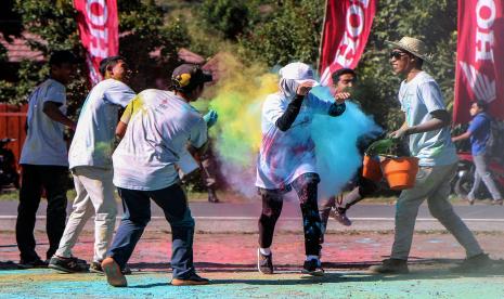 Panitia melemparkan bubuk warna-warni ke arah peserta saat memasuki garis finish Rinjani Color Run di Lapangan Sembalun, Lombok Timur, NTB, Sabtu (20/8/2022). Ajang lari santai tiga kilometer dengan khas taburan bubuk warna-warni tersebut diselenggarakan oleh Perum LKBN Antara Biro NTB dalam upaya menggeliatkan ekonomi masyarakat khususnya di sektor pariwisata dan produk kreatif.