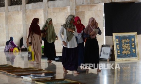 Panitia memasang kaligrafi untuk mempersiapkan pameran di Masjid Istiqlal, Jakarta, Ahad (19/2). 