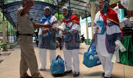 Panitia Pelaksana Ibadah Haji (PPIH) memeriksa kartu kamar calon jamaah haji kloter 20 asal Jakarta saat memasuki Asrama Haji Pondok Gede, Jakarta, Senin (23/9). (Republika/Yasin Habibi)