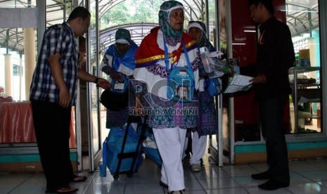 Panitia Pelaksana Ibadah Haji (PPIH) memeriksa kartu kamar calon jamaah haji kloter 20 asal Jakarta saat memasuki Asrama Haji Pondok Gede, Jakarta, Senin (23/9).