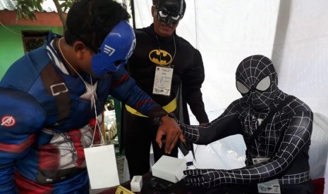 Panitia Pemungutan Suara di TPS 005 Kelurahan Babat Jerawat, Kecamatan Pakal, Surabaya, berpakaian ala super hero di Avenger untuk menarik minat masyarakat menyalurkan hak pilihnya pada Pemilu 2019, Rabu (17/4).