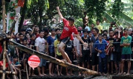 Panjat pinang di tengah sungai yang berlangsung di Kalimalang, Jakarta Timur