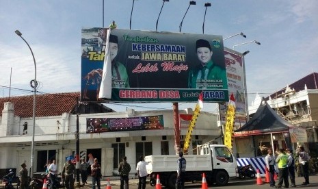 Panwaslu tengah mencopot billboard bergambar Wali Kota Tasikmalaya nonaktif Budi Budiman dan Bupati Tasikmalaya Uu Ruzhanul Ulum, Rabu (28/12). Pencopotan dilakukan karena melanggar aturan alat peraga kampanye.