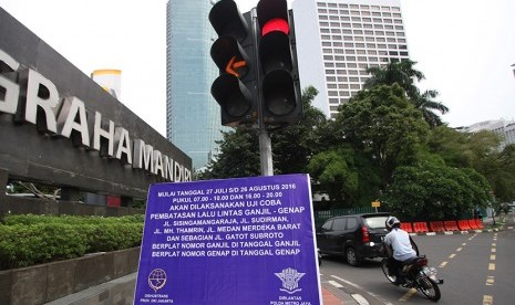 Papan informasi uji coba penerapan sistem lalu lintas plat Ganjil Genap terpampang di Jalan Underpas Dukuh Atas, Sudirman, Jakarta, Senin (25/7).