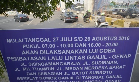 Papan informasi uji coba penerapan sistem lalu lintas pelat ganjil-genap terpampang di kawasan Blok M - Senayan, Jakarta, Selasa (26/7). 