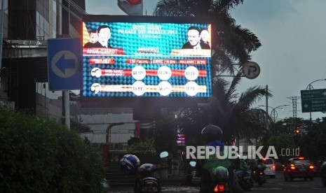  Papan reklame menampilkan hasil hitung cepat hasil Pilkada DKI putaran kedua di Jakarta, Rabu (19/4).