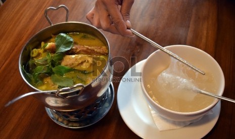 Papeda dimakan dengan cara menggulungnya dengan sumpit lalu disantap bersama kuah kuning yang gurih.