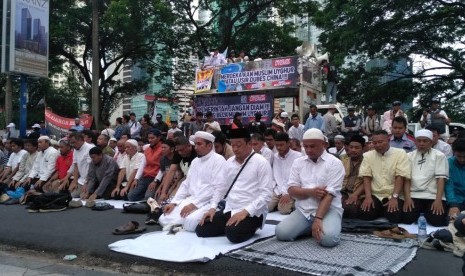 Para aksi bela muslim Uighur melakukan shalat ashar di depan gedung kedutaan besar RRC, Jakarta Selatan, Jumat ( 21/12).