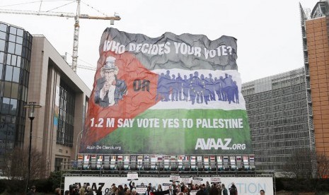 Para aktivis membentangkan bendera Palestina raksasa dalam aksi mendukung negara Palestina merdeka di luar Gedung Dewan Uni Eropa di Brussels, Senin (19/11-2013). (Reuters/Francois Lenoir)