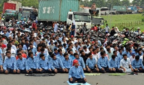 Para buruh melakukan Shalat Jumat saat aksi blokir jalan tol Jakarta-Cikampek, Cibitung, Jawa Barat (ilustrasi).