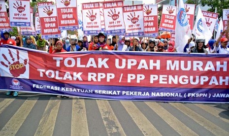 Para buruh yang tergabung dalam Federasi Kesatuan Serikat Pekerja Nasional (FKSPN) membawa poster sambil meneriakkan tuntutannya saat berunjuk rasa menuntut upah layak, di Semarang, Jateng. (Antara/R. Rekotomo)