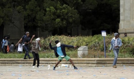 Para demonstran di Universitas Witwatersrand Afrika Selatan menggulingkan sebuah kendaraan polisi dan melempar bebatuan ke arah kendaraan lainnya pada Selasa (4/10), dalam unjuk rasa ricuh dan menolak besarnya biaya pendidikan.