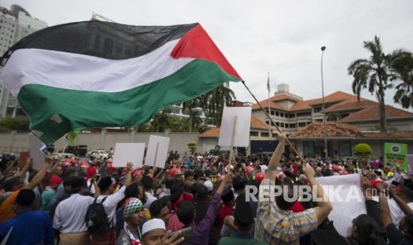 Para demonstran mengibarkan bendera Palestina di luar Kedutaan Besar AS di Kuala Lumpur, Malaysia, Jumat, (8 /12). Muslim Malaysia, termasuk anggota partai yang berkuasa, mengadakan demonstrasi di luar Kedutaan Besar AS mengenai tindakan kontroversial Washington untuk mengakui Yerusalem sebagai ibukota Israel .