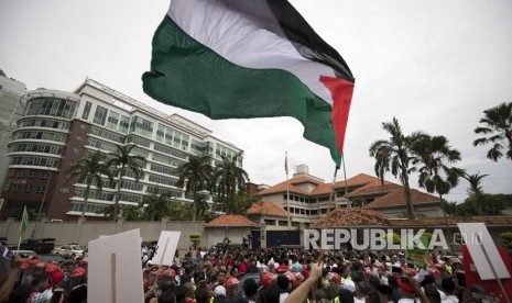 Para demonstran mengibarkan bendera Palestina di luar Kedutaan Besar AS di Kuala Lumpur, Malaysia, Jumat, (8 /12). Muslim Malaysia, termasuk anggota partai yang berkuasa, mengadakan demonstrasi di luar Kedutaan Besar AS mengenai tindakan kontroversial Washington untuk mengakui Yerusalem sebagai ibukota Israel .