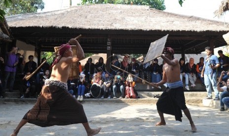 Warga menyaksikan tradisi adu rotan atau tari presean di Desa Sade, Lombok, Nusa Tenggara Barat (Ilustrasi)