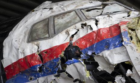 Para hakim pengadilan dan pengacara terlihat di dalam saat mereka melihat puing-puing pesawat Malaysia Airlines MH17 yang direkonstruksi, di pangkalan udara militer Gilze-Rijen, Belanda selatan, Rabu, 26 Mei 2021.