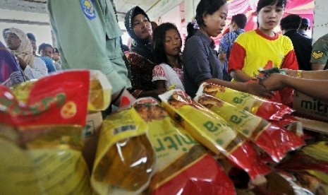 Para ibu tampak antre saat membeli minyak goreng kemasan di sebuah bazar.