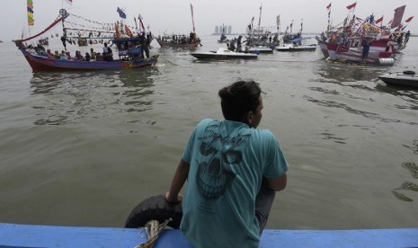 Para nelayan bersama keluarganya berlayar untuk mengikuti sedekah bumi Nadran di Muara Angke, Jakarta Utara, Minggu (13/12).