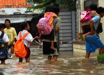 Para orang tua menggendong anaknya usai pulang sekolah dikawasan Kampung Melayu Kecil, jakarta Selatan, Kamis (23/2). (Republika/Agung Supriyanto)