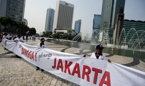 Para panitia pengawas lapangan (PPL) Panwaslu memegang spanduk Bangga Jakarta dalam aksi simpati Panwaslu untuk DKI Jakarta Pemilu Damai di Bundaran HI, Jakarta, Ahad (7/10). 