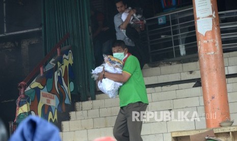 Para pedagang berusaha menyelamatkan barang-barangnya saat peristiwa kebakaran di Pasar Kosambi, Kota Bandung, Ahad (19/5).