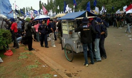 Para pedagang kaki lima (PKL) mendulang rizki dari para buruh yang menggelar demo di Jakarta, Kamis (12/7).