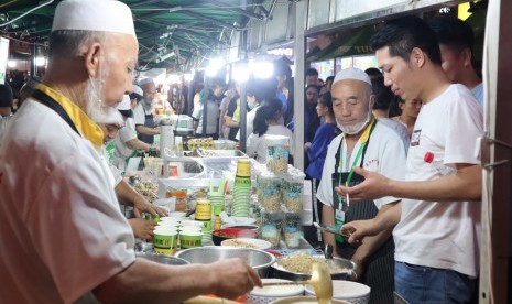 Para pedagang makanan halal di pasar malam melayani pembeli di Kota Lanzhou, Provinsi Gansu, Cina, Jumat (6/7). Provinsi Gansu yang dihuni sekitar 3,4 persen umat Islam dari total populasi 27 juta jiwa itu merupakan salah satu penghasil makanan halal terbesar di Cina yang sudah merambah 40 negara lainnya. 